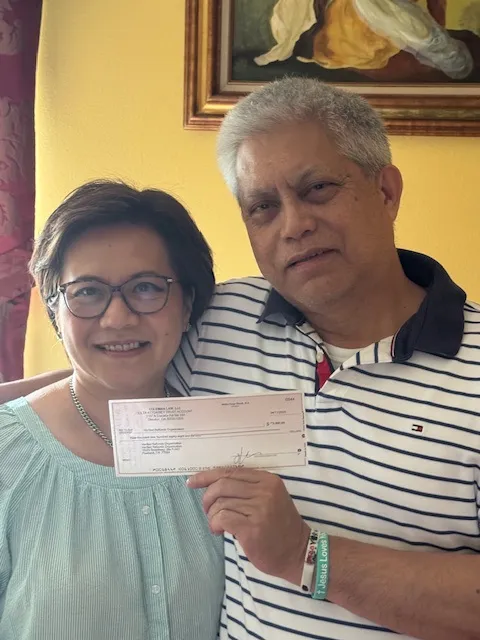 Vic and Racellia holding a check